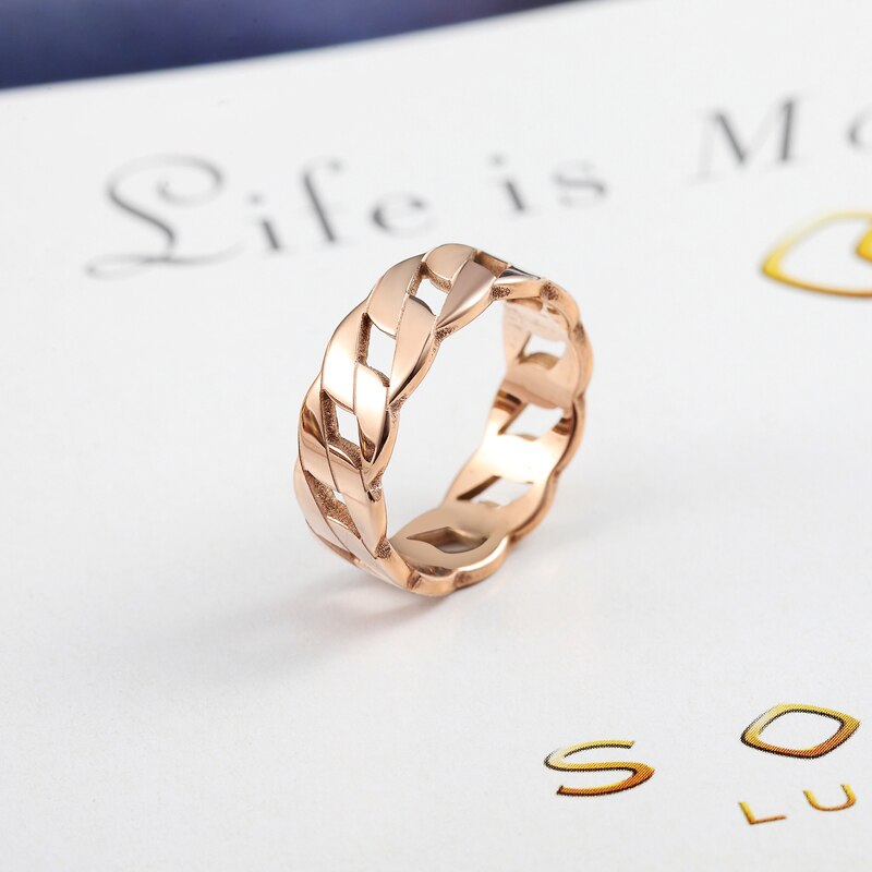Cassie braided rose gold ring with polished intertwined design on white surface