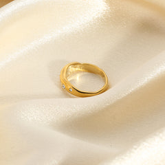 Elegant gold snake shape ring with small gemstones on shiny beige fabric background