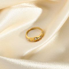 Elegant gold snake shape ring with small embedded crystals on smooth satin fabric