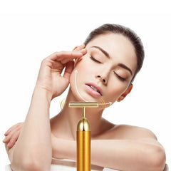 Woman using 24k gold facial roller on her cheek for skin massage and rejuvenation