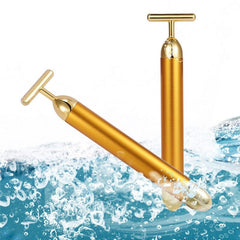 24k gold facial roller in metallic gold with T-shaped massage head over water splash background
