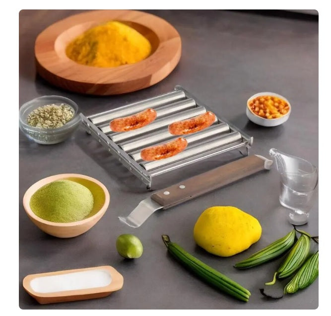 Stainless steel hot dog roller with sausages cooking surrounded by spices and vegetables on a gray surface